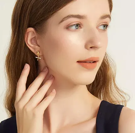 Model wearing gold skull earrings