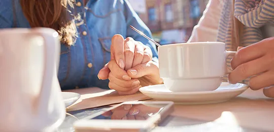 Couple Holding Hands in Coffee